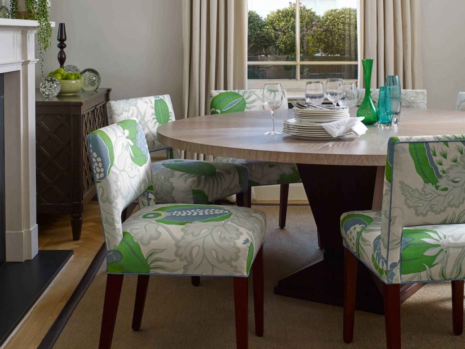 Grey dining room with upholsterered chairs in leaf print