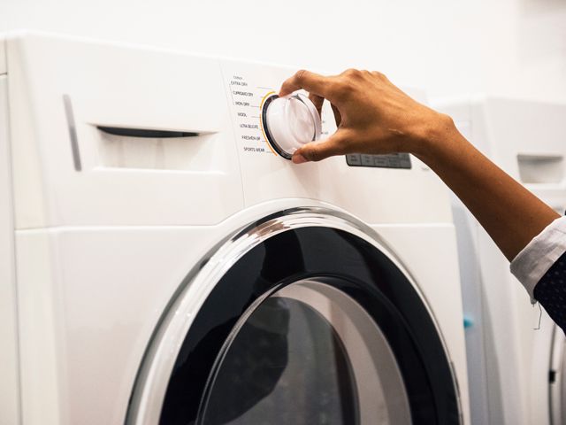 Close up of woman using washing machine