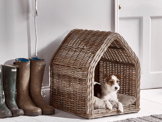 rattan dog bed from coxandcox in the shape of a house with washable cushion