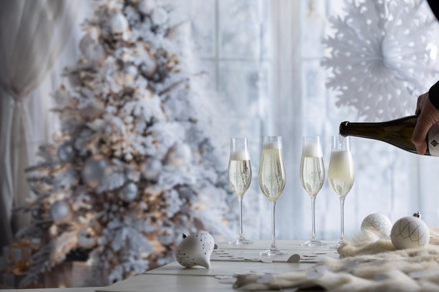 Crystal glasses for New Year's eve celebrations with christmas tree in background