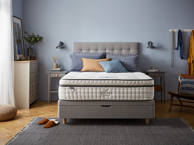 Premium mattress in a blue bedroom with grey bed frame
