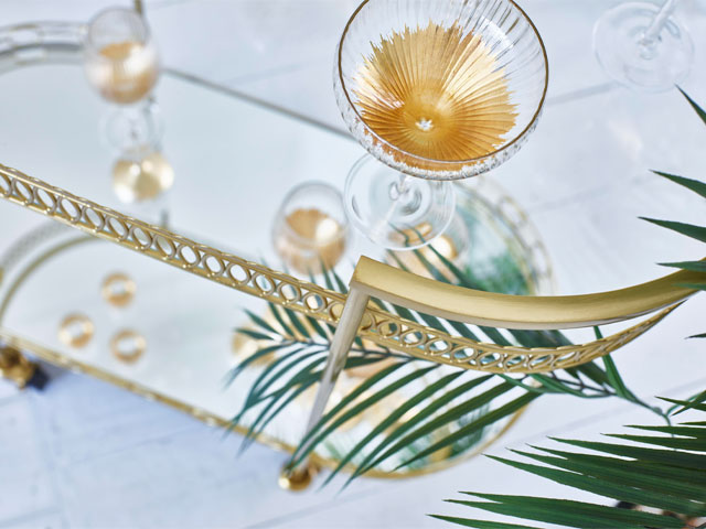 oliver bonas cocktail trolley with gold trim and gold flecked champagne saucers