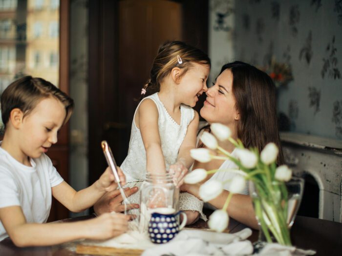 Two children looking happy as they bake with their mum
