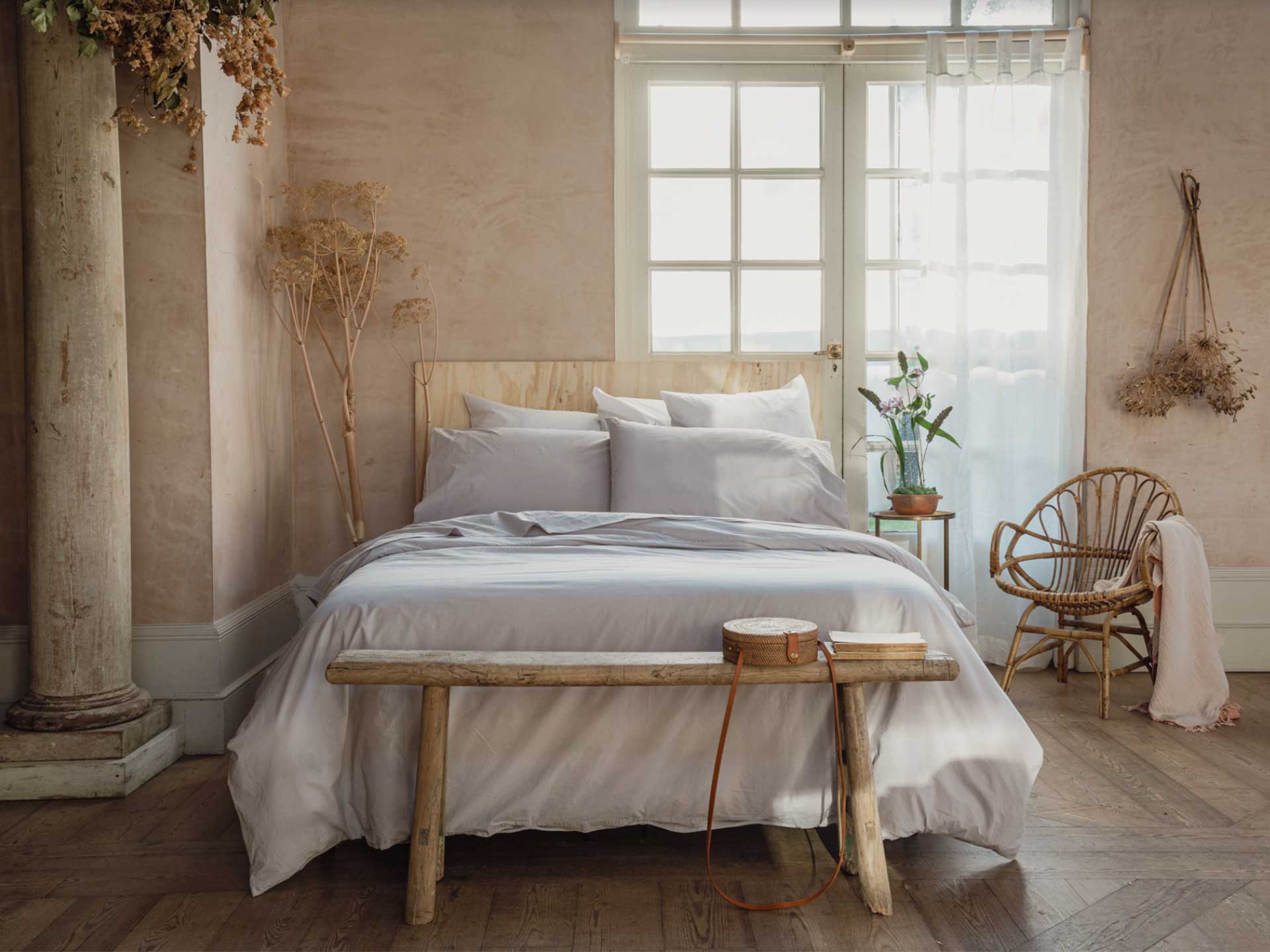 Pair limewash walls with linen bedlinen for a textured bedroom
