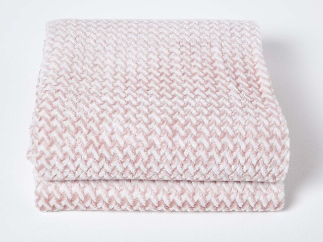 Pink cosy blanket folded on white background