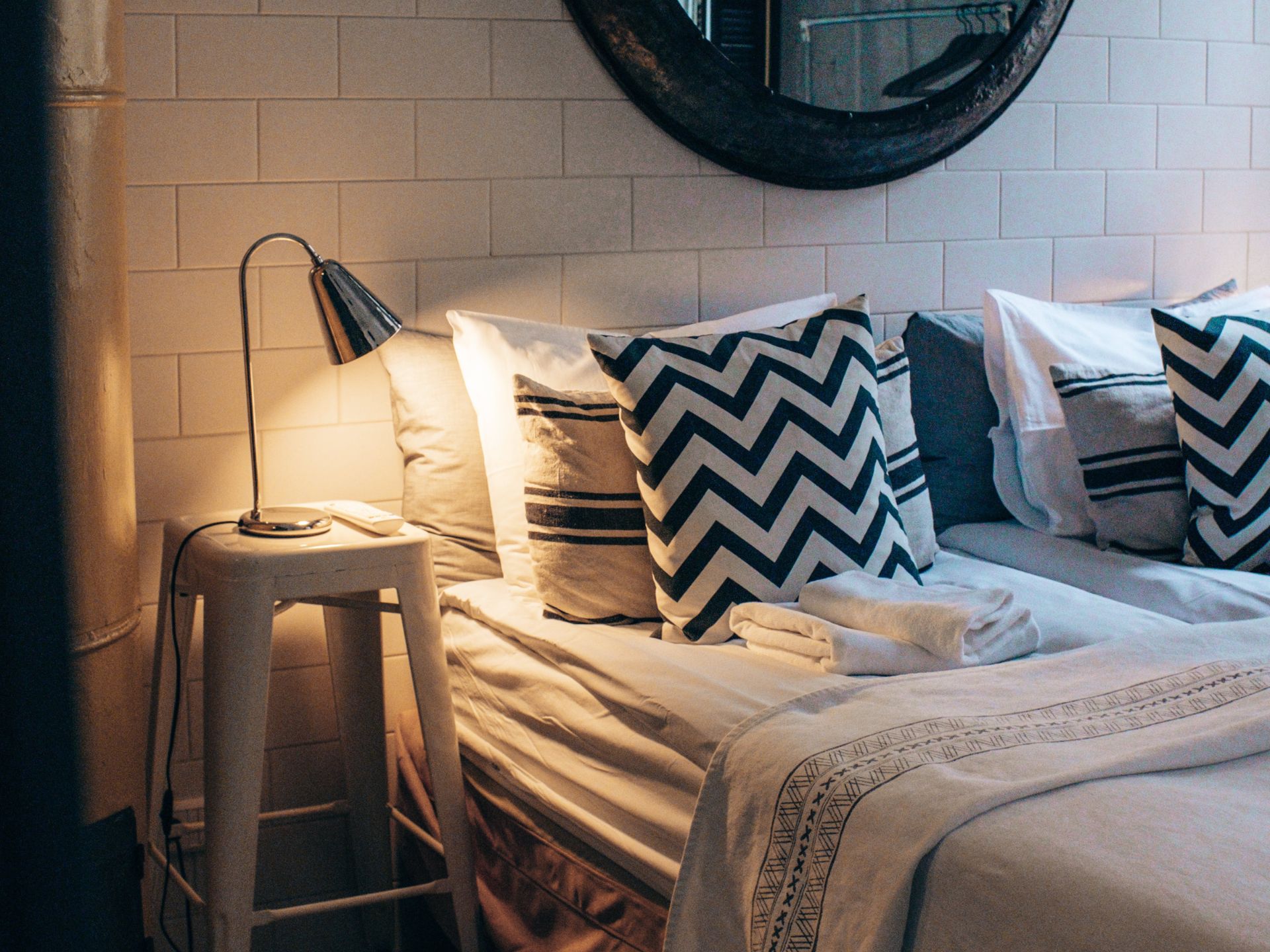 Cosy bed with layered cushions and fabrics